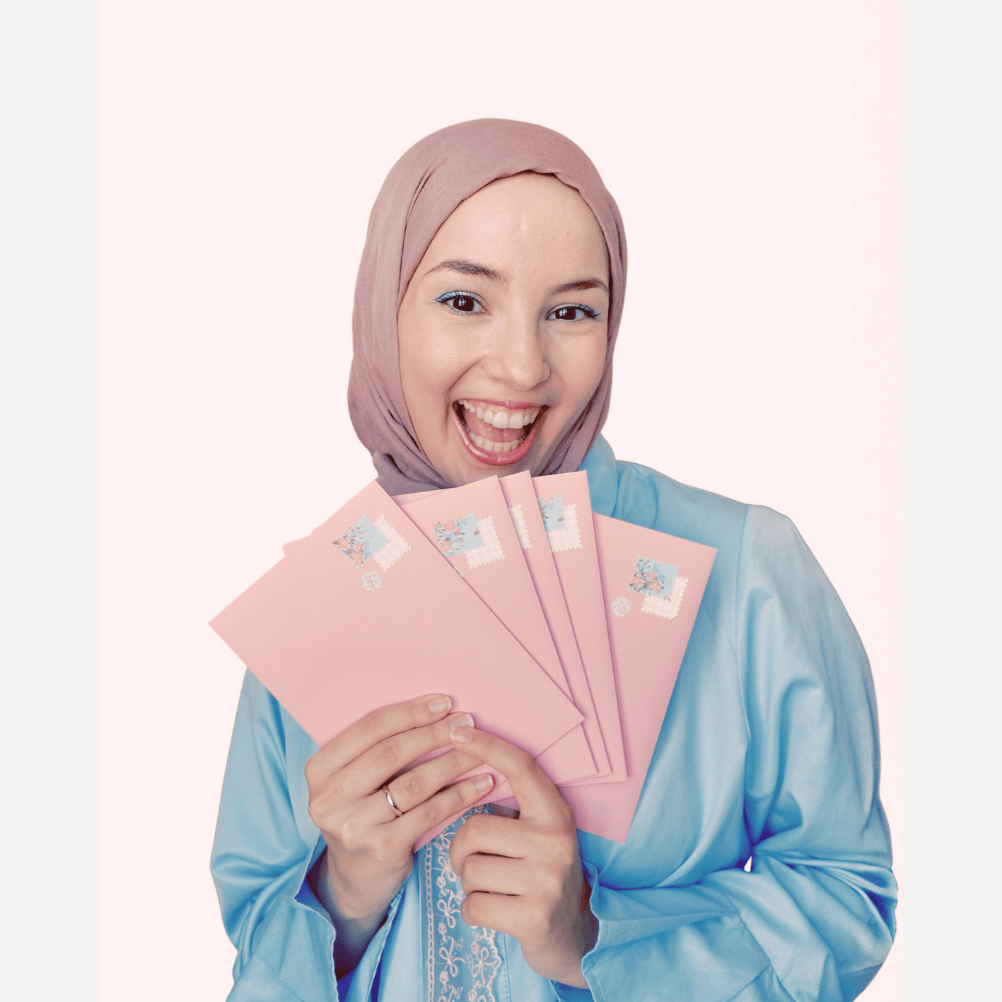 Şeyda Horasanlı smiling, holding a fan of pink envelopes
